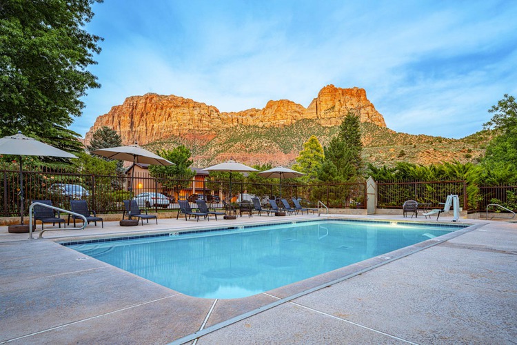 Outdoor pool with lounge chairs and canyon view